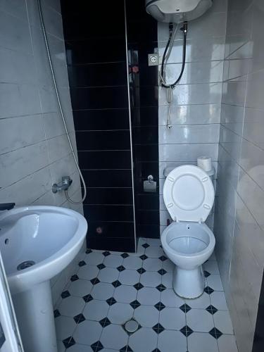 ein Badezimmer mit weißer Toilette und Waschbecken in der Unterkunft Hotel Evrazia in Ureki