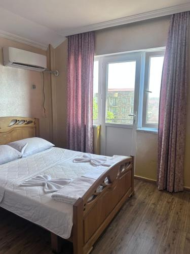 ein Schlafzimmer mit einem großen Bett vor einem Fenster in der Unterkunft Hotel Evrazia in Ureki