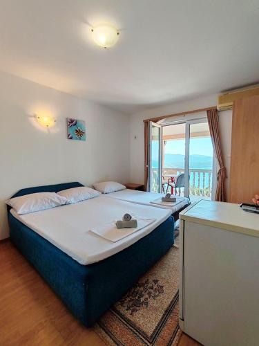 a bedroom with a large bed and a balcony at Apartment & Rooms Tempera in Neum