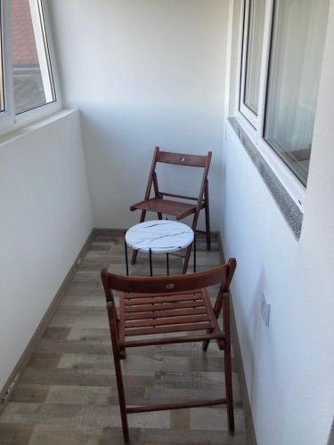 two chairs and a table in a room with a window at ,, LA MAISON CONCORDIA '' in Cincu