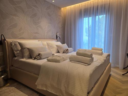 a bedroom with a large white bed with a window at Villa Tedi in Podaca
