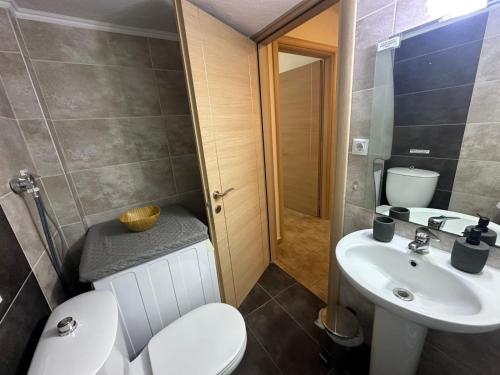 a bathroom with a toilet and a sink at Otium Apartment in Nea Peramos