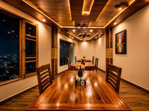 a dining room with a wooden table and chairs at Hotel Woods inn Dalhousie #MBS Travels # Rooftop # Restaurant # Top Rated Property in Dalhousie