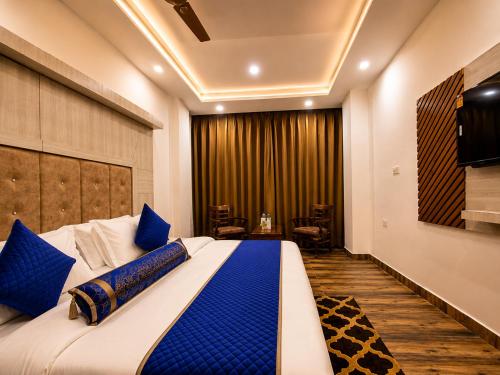 a bedroom with a large bed with blue pillows at Hotel Woods inn Dalhousie #MBS Travels # Rooftop # Restaurant # Top Rated Property in Dalhousie