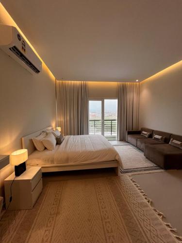 a bedroom with a large bed and a couch at فيلا صلاله بالم salalah palm villa in Salalah