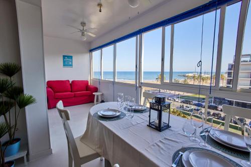 a dining room with a table with a view of the ocean at Beachfront Apartment with Sea Views & Pool - El Puig in El Puig