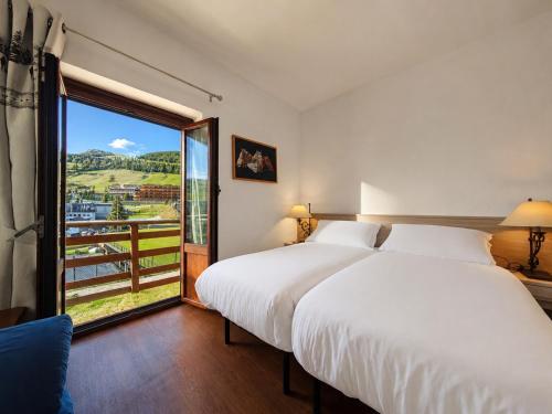 a bedroom with a large bed and a large window at Hostdomus - Fraiteve Suite in Sestriere