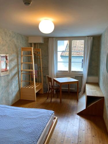 a bedroom with a bed and a table and a window at Hotel Genossenschaft Kreuz in Solothurn
