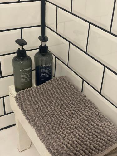 two bottles ofodorizers sitting on a bench in a bathroom at Rincón de Beluso, Bueu in Pontevedra