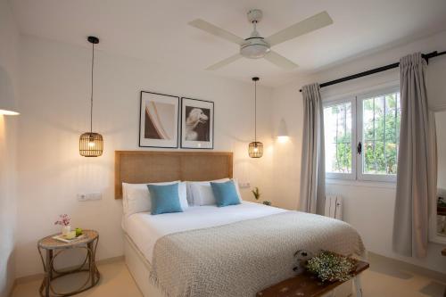a bedroom with a large bed with blue pillows at Quinta la Sal by SingularStays in Jávea