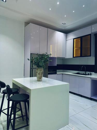 a kitchen with a counter with chairs and a vase at Diah Homes Apartment in Benin City