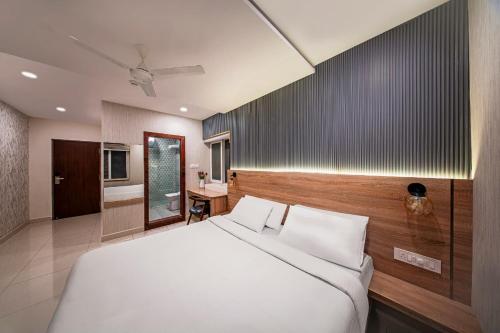 a bedroom with a white bed and a wooden wall at Harvey's Hotel in Hyderabad