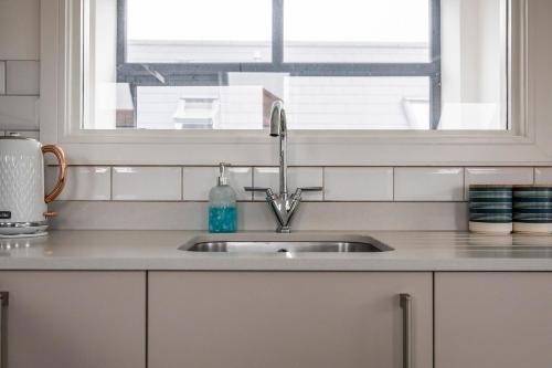 a kitchen counter with a sink and a window at Seaview apartment in Southbourne