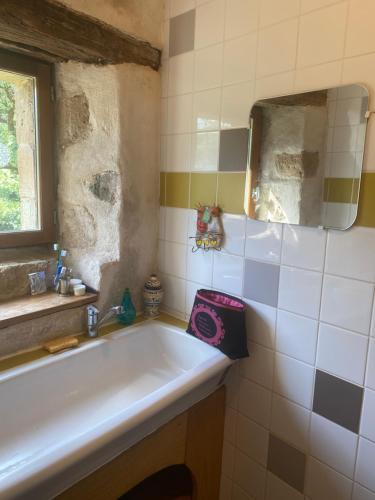 a bathroom with a tub and a sink and a window at Auberge de Lascours in Ceilhes-et-Rocozels