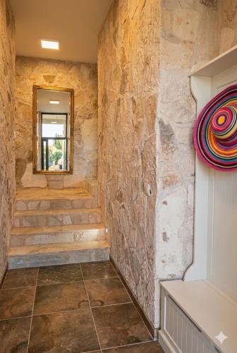 a bathroom with stone walls and stairs with a window at Loft in Kruce in Kruče