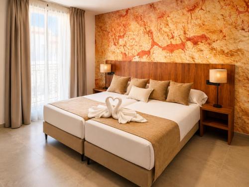 a bedroom with a large white bed in a room at Hostal Rural La Mejorada in Alpera