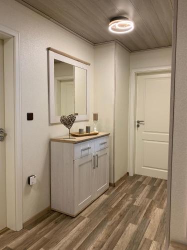 a bathroom with a sink and a mirror and a door at Privatzimmer Guhl in Munster