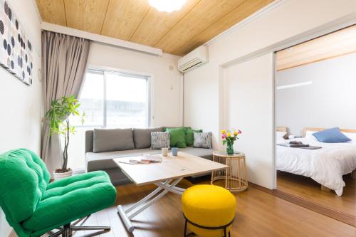 a living room with a couch and a table and a bed at Sunlife in Sendai