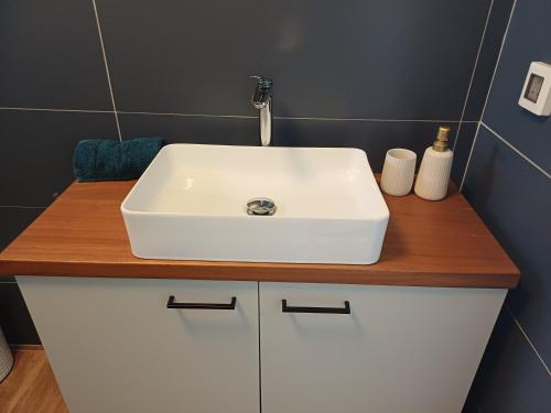 a bathroom with a white sink on a wooden counter at Beachfront Bliss in Pissouri