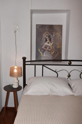 a bedroom with a bed with a painting on the wall at Maritsa's Cozy Apartment in Mytilinioí
