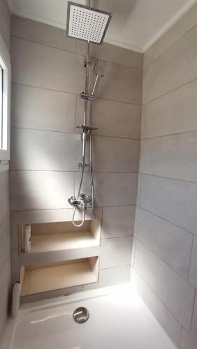 a bathroom with a shower with a sink and a light at Maritsa's Cozy Apartment in Mytilinioí