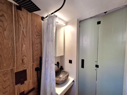 a bathroom with a white shower curtain next to a door at The Handcrafted Haven 2 min to Central Square in Missolonghi