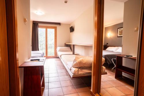 a hotel room with a bed and a bedroom at Hotel Ransol in El Tarter