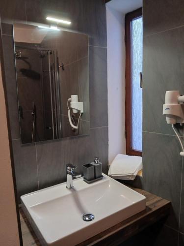 a bathroom with a white sink and a mirror at La Casa nel Borgo in Muggia