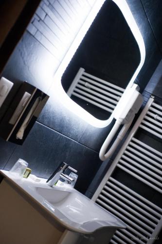 a bathroom with a sink and a mirror on the wall at Hôtel de France in Montmarault
