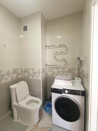 a bathroom with a toilet and a washing machine at Darkhan apartment in Darhan