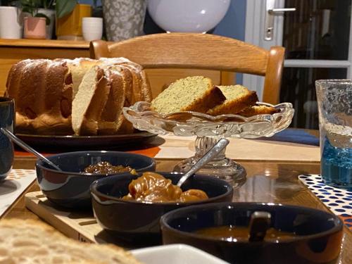 a table with a plate of bread and bowls of food at Au Jardin de Mireille in Leffrinkhoucke