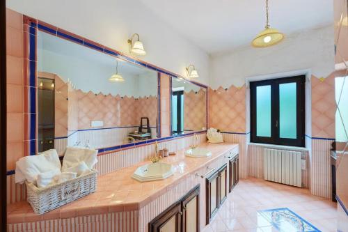 a bathroom with two sinks and a large mirror at La dimora dei 5 sensi in Faiano