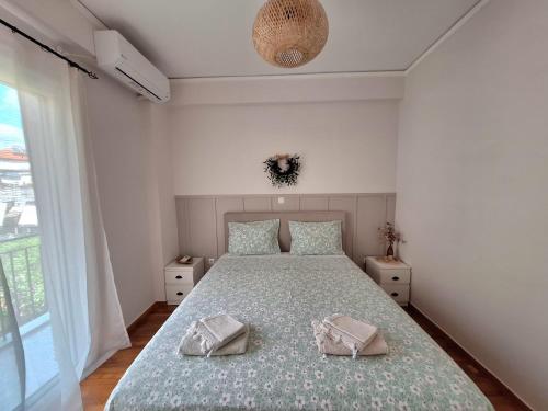 a bedroom with a bed with two towels on it at The Handcrafted Haven 2 min to Central Square in Missolonghi