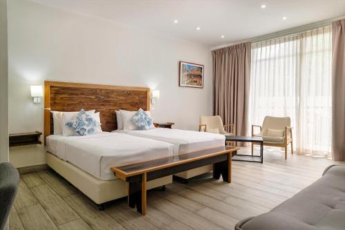 a hotel room with a large bed and a couch at Voilà Beau Vallon in Beau Vallon