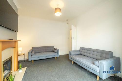 a living room with two couches and a fireplace at Millfield House by Blue Skies Stays in Middlesbrough