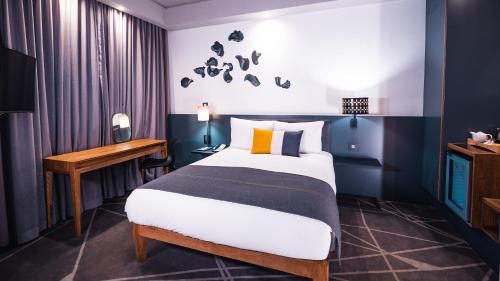 a hotel room with a bed and a desk at Piazza Hotel Montecasino in Johannesburg