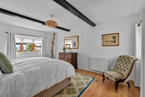 a bedroom with a bed and a chair and a window at Finest Retreats - Poundtree in Wherwell
