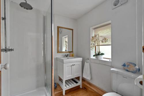 a white bathroom with a sink and a mirror at Finest Retreats - Poundtree in Wherwell