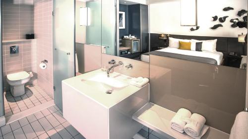 a bathroom with a sink and a bed at Piazza Hotel Montecasino in Johannesburg