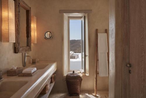 a bathroom with a sink and a mirror and a window at The Margi Villa Mykonos in Agios Sostis Mykonos