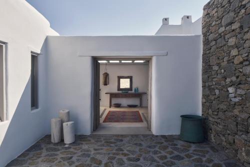 a hallway of a house with a stone wall at The Margi Villa Mykonos in Agios Sostis Mykonos