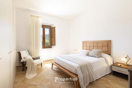 a white bedroom with a bed and a chair at Villa Rurale con Vista by Propertize in Monti