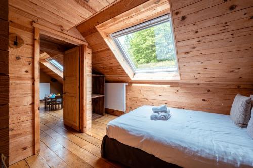 a bedroom with a bed in a wooden cabin at Les Gîtes de Sprimont - Le Cosy in Sprimont