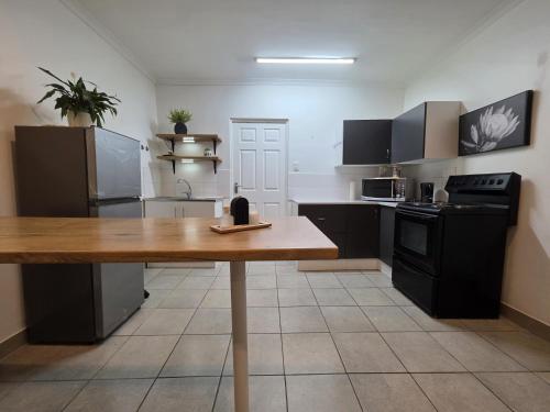 a large kitchen with a wooden table in it at The041Stay in Gqeberha