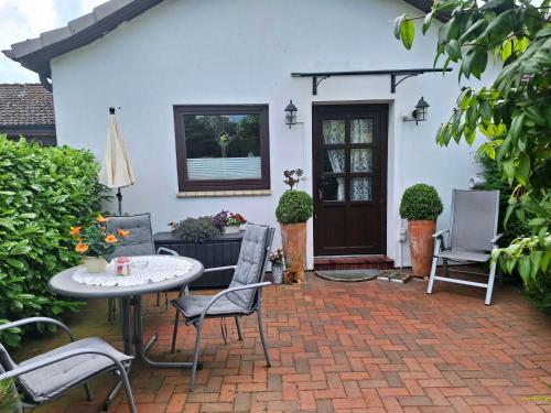 a patio with a table and chairs in front of a house at "Schöne Auszeit" Ferienwohnung in Wiemersdorf