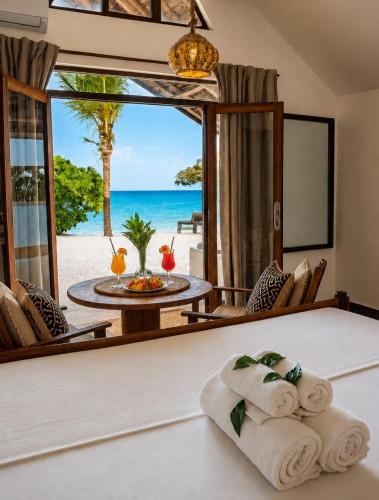 a room with a bed with a view of the ocean at Juana Ocean Villas in Makunduchi