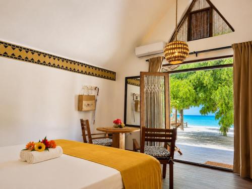 a bedroom with a bed and a view of the ocean at Juana Ocean Villas in Makunduchi