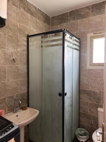 a bathroom with a shower and a sink at Chalet in La mera north coast in Zāwiyat al ‘Awwāmah