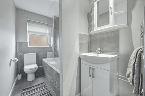 a white bathroom with a sink and a toilet at Saint Johns Rest in Biggleswade
