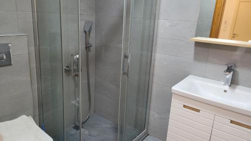 a shower with a glass door next to a sink at Tayfun Apart Hotel in Oludeniz